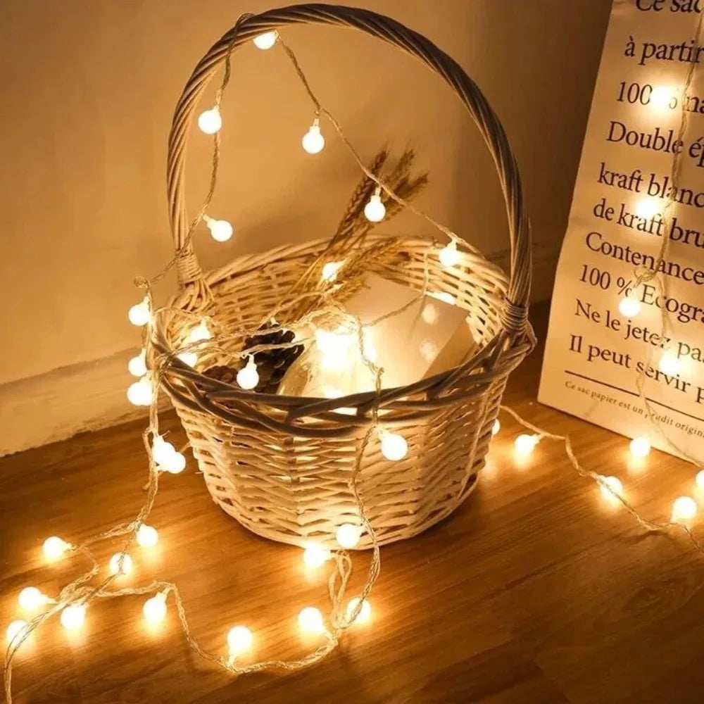 Warm white globe string lights draped around a decorative wicker basket