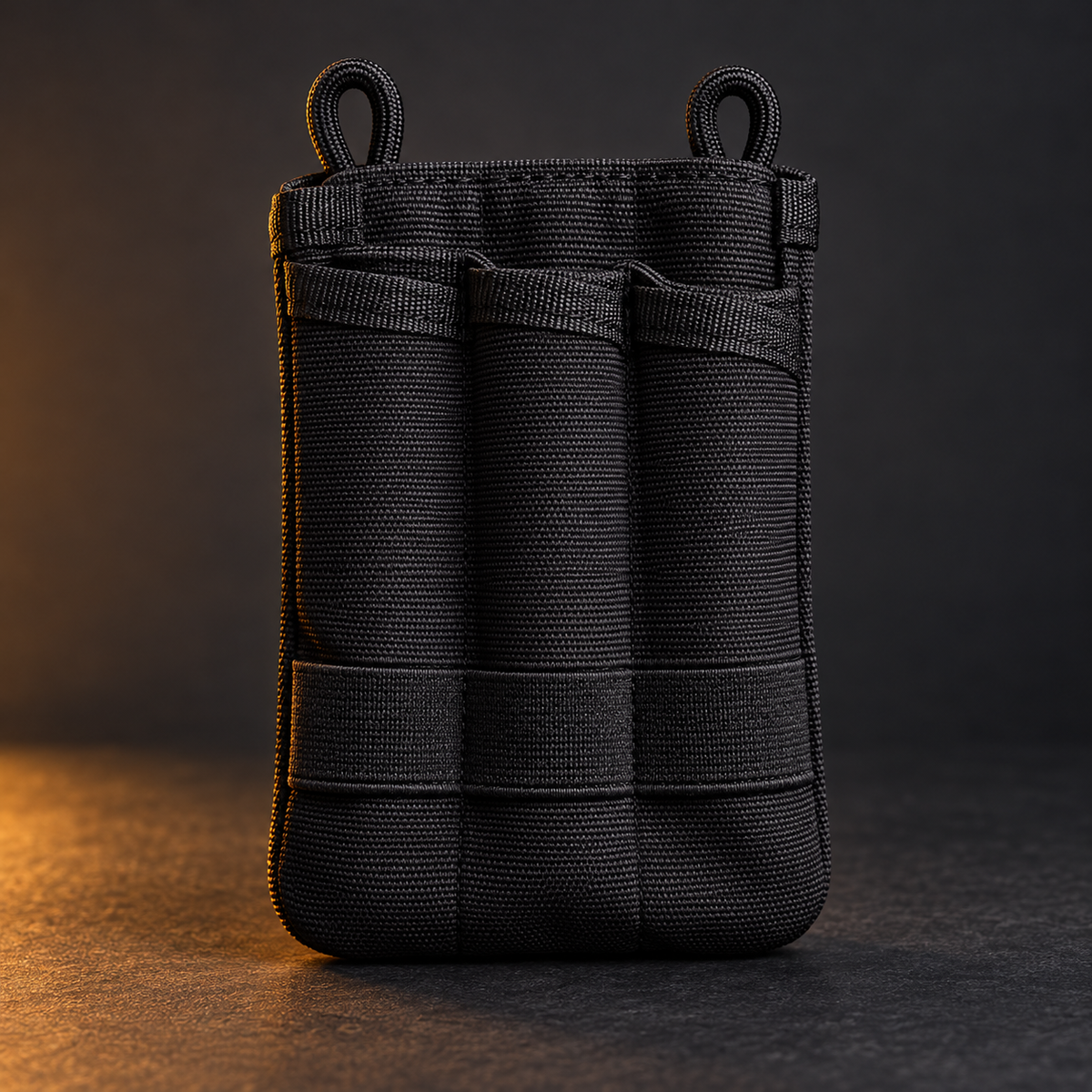 Empty black MOLLE-style EDC organizer pouch on a charcoal background